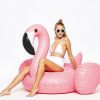 Giant inflatable flamingos ride on floating objects in the swimming pool; equipped with fast valve swimming rafts; suitable for summer party decoratio